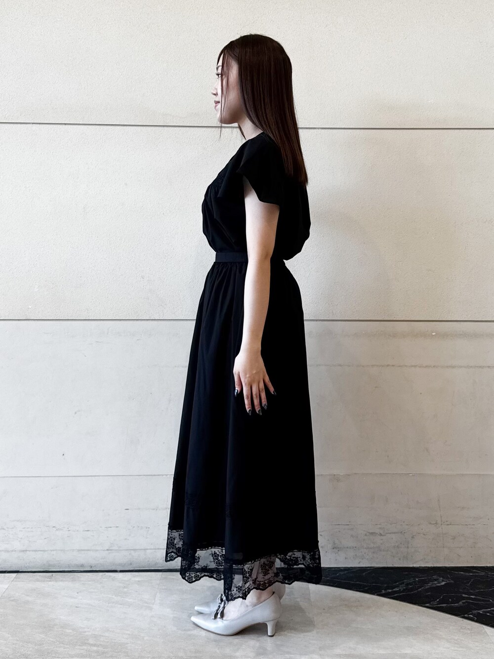 ブラック系のシャツ/ブラウス、ブラック系のスカート、ベージュ系のパンプスを着用したレディースの夏コーディネートの2枚目の写真
