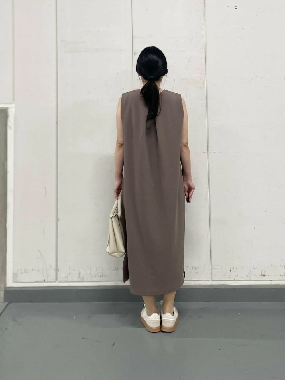 ホワイト系のトートバッグ、ホワイト系のタンクトップ、ブラウン系のワンピースを着用したレディースの夏コーディネートの4枚目の写真