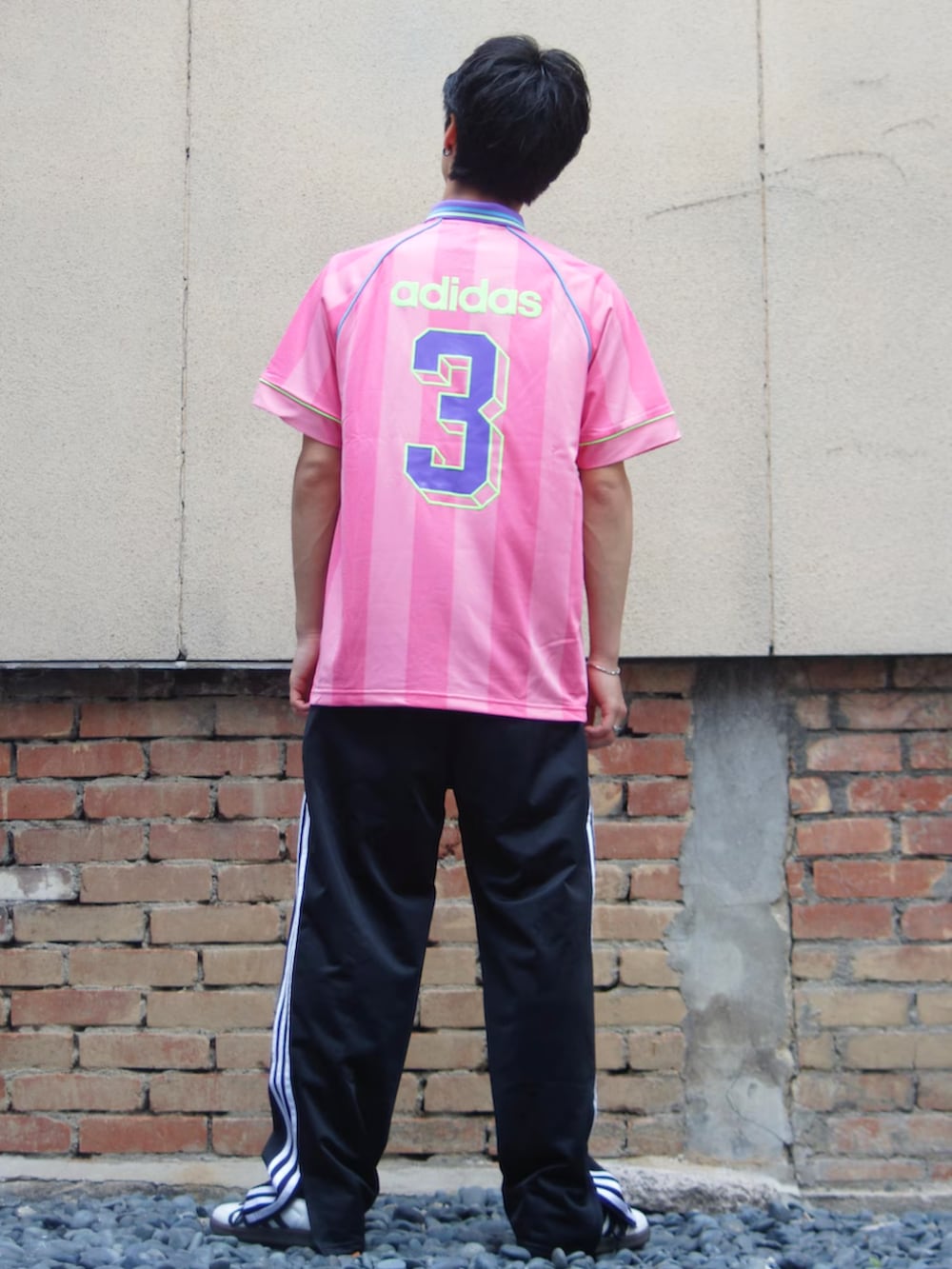 ブラック系のスウェットパンツ、ホワイト系のスニーカー、ピンク系のTシャツ/カットソーを着用したメンズの夏コーディネートの3枚目の写真