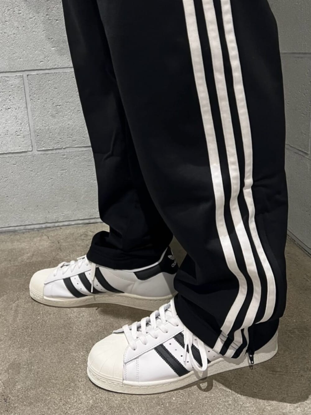 ブラック系のスウェットパンツ、ブラック系のジャージ、ホワイト系のシューズを着用したメンズの秋コーディネートの4枚目の写真