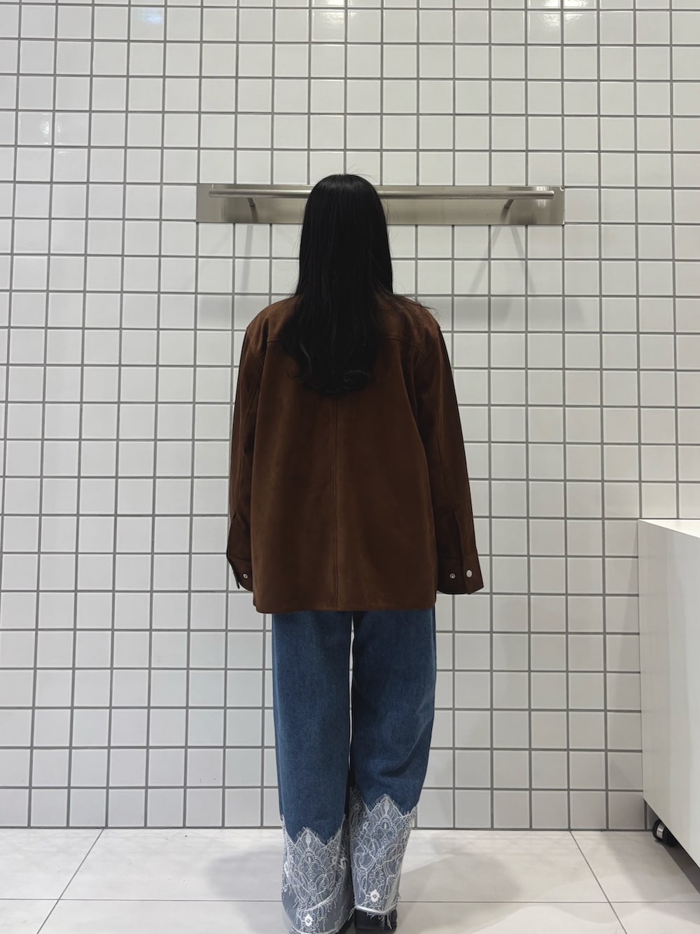 ブラウン系のその他アウター、グレー系のニット/セーター、ブルー系のデニムパンツを着用したレディースの冬コーディネートの3枚目の写真