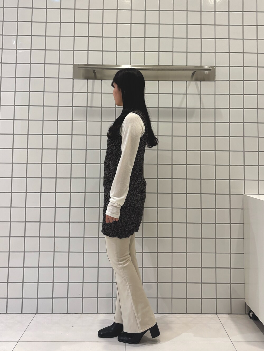 ホワイト系のシャツ/ブラウス、ブラック系のベスト、ベージュ系のその他パンツを着用したレディースの冬コーディネートの2枚目の写真