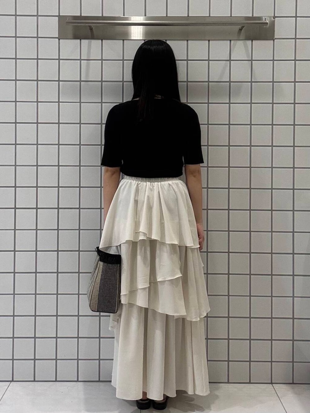 ブラック系のサンダル、ホワイト系のスカート、ブラック系のニット/セーターを着用したレディースの春コーディネートの3枚目の写真