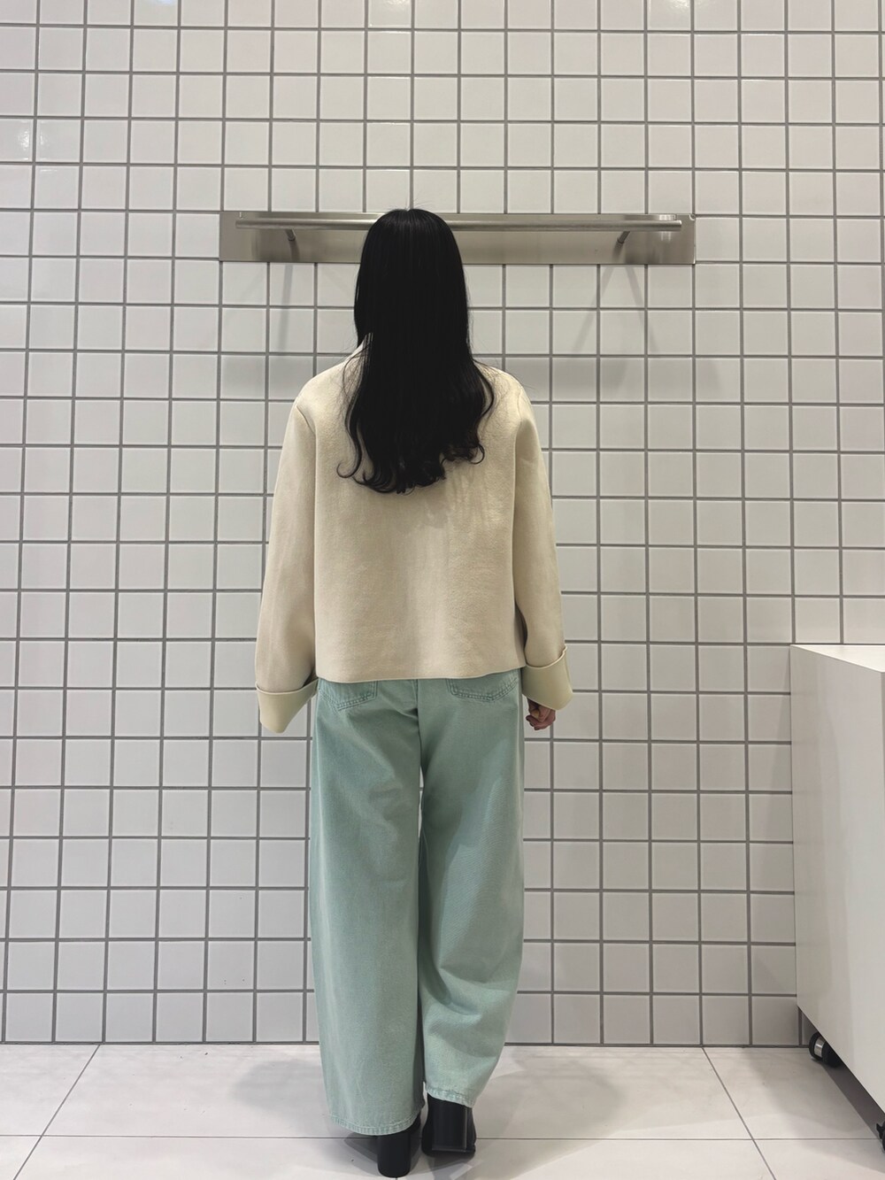 グレー系のニット/セーター、グリーン系のデニムパンツ、ホワイト系のニット/セーターを着用したレディースの冬コーディネートの3枚目の写真