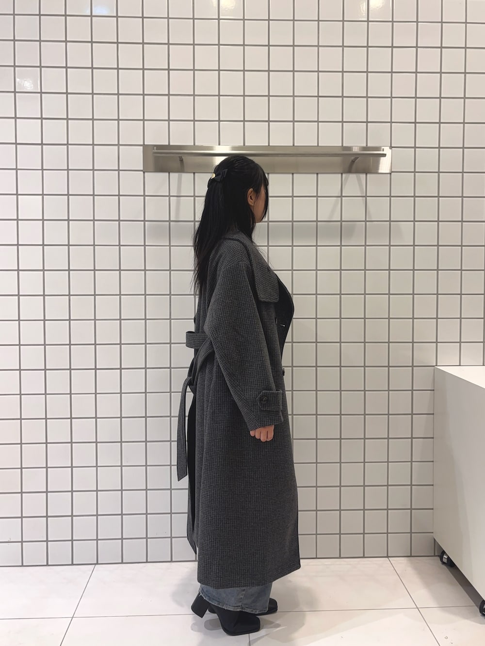 グレー系のニット/セーター、グレー系のその他アウター、ブラック系のブーツを着用したレディースの秋コーディネートの3枚目の写真