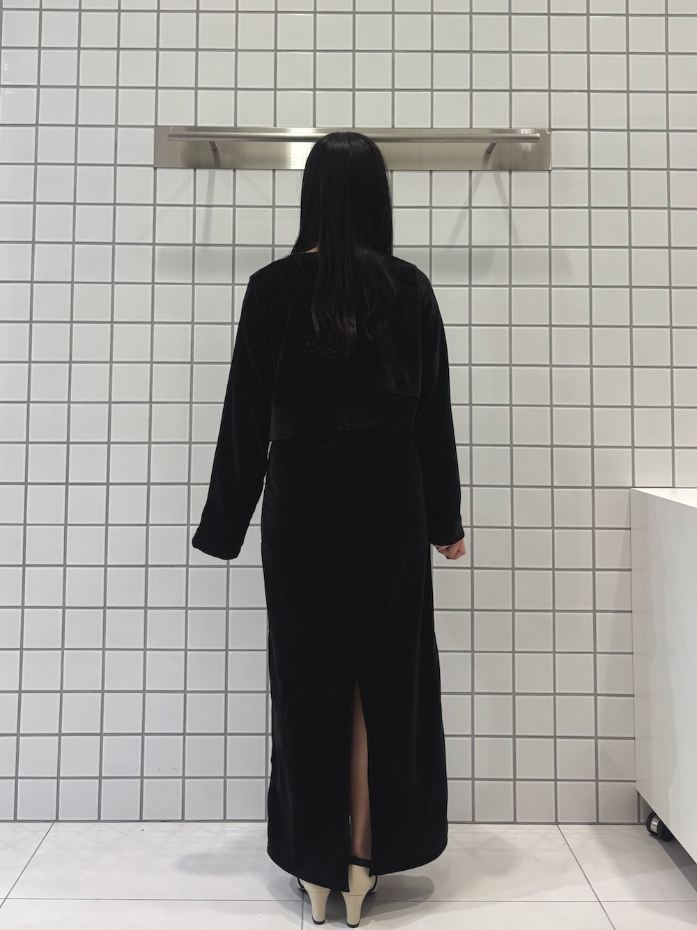 ホワイト系のパンプス、ブラック系のワンピースを着用したレディースの冬コーディネートの3枚目の写真