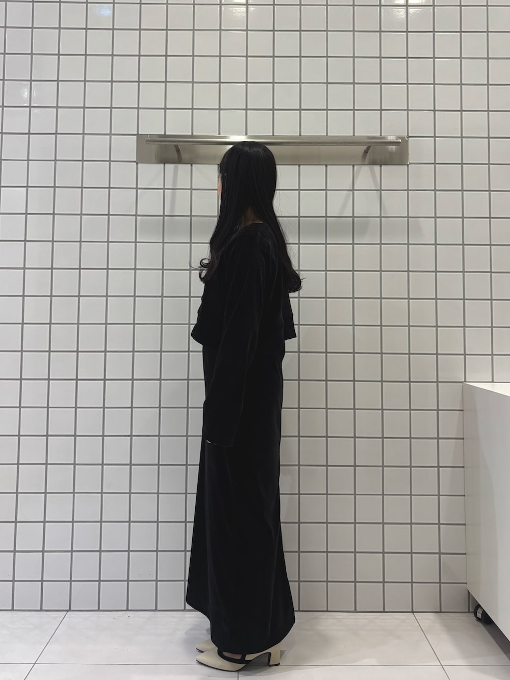 ホワイト系のパンプス、ブラック系のワンピースを着用したレディースの冬コーディネートの2枚目の写真