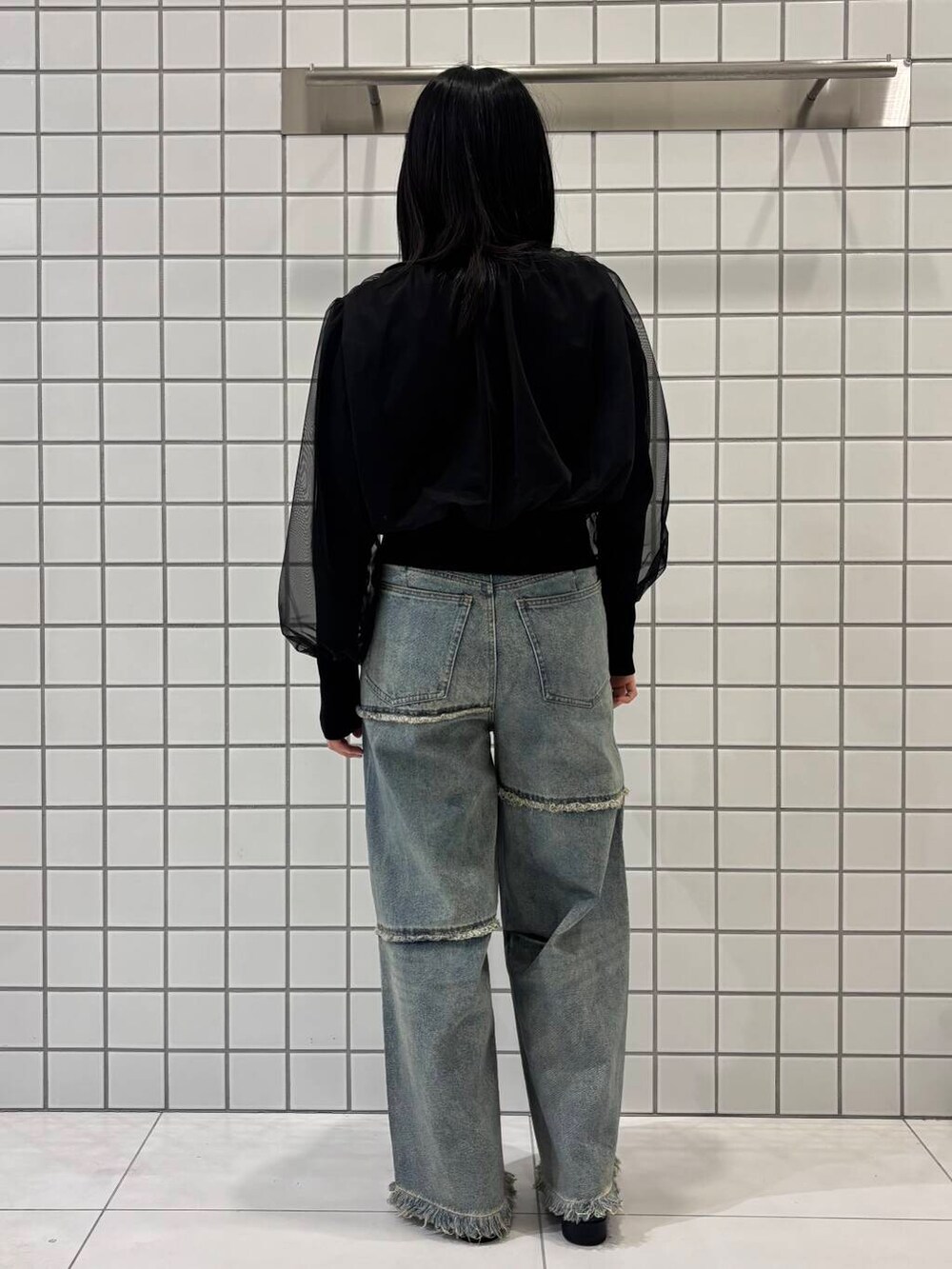 ブラック系のブーツ、ブルー系のデニムパンツ、ブラック系のカーディガン/ボレロを着用したレディースの冬コーディネートの3枚目の写真