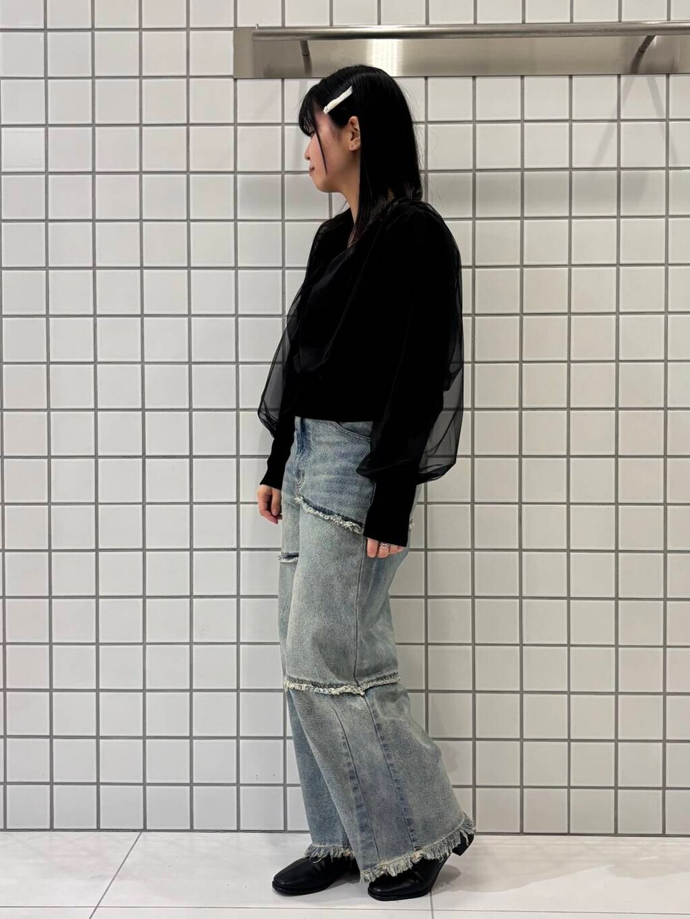 ブラック系のブーツ、ブルー系のデニムパンツ、ブラック系のカーディガン/ボレロを着用したレディースの冬コーディネートの2枚目の写真