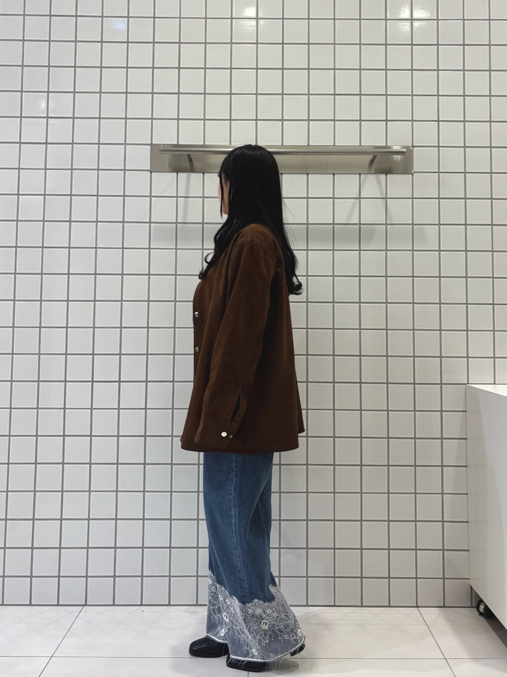 ブラウン系のその他アウター、グレー系のニット/セーター、ブルー系のデニムパンツを着用したレディースの冬コーディネートの2枚目の写真