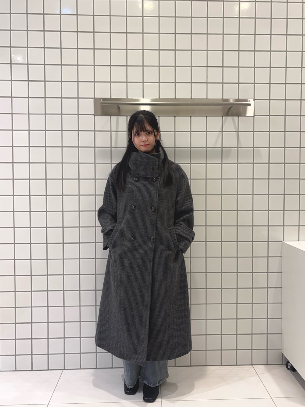 グレー系のニット/セーター、グレー系のその他アウター、ブラック系のブーツを着用したレディースの秋コーディネートの2枚目の写真