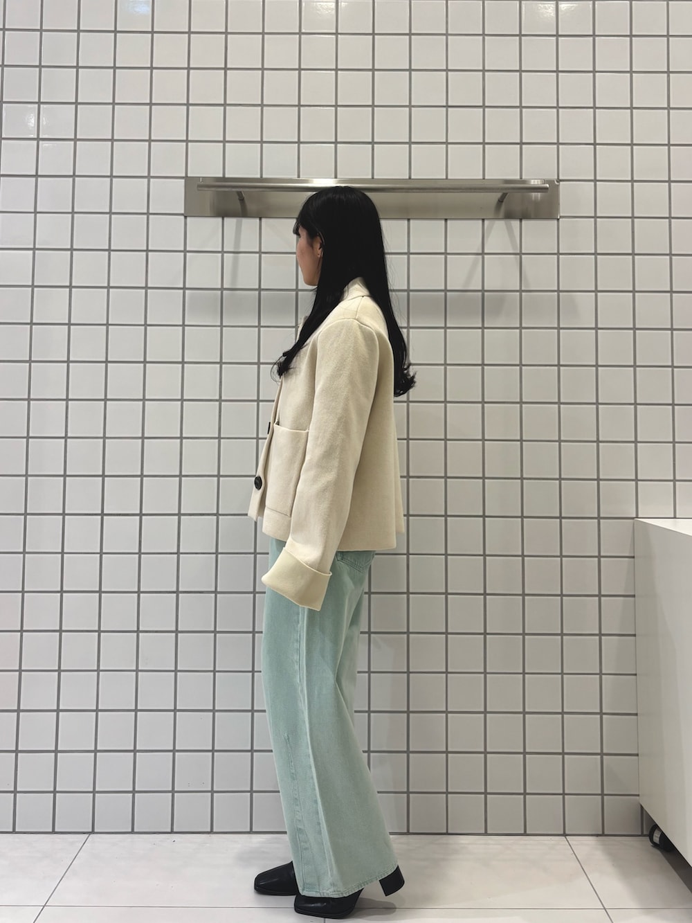 グレー系のニット/セーター、グリーン系のデニムパンツ、ホワイト系のニット/セーターを着用したレディースの冬コーディネートの2枚目の写真