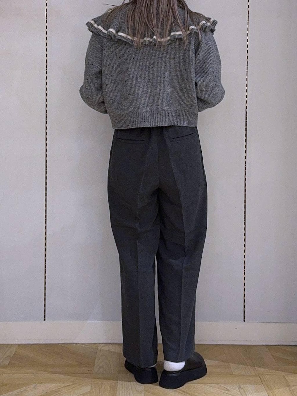 ホワイト系のニット/セーター、グレー系のその他パンツ、ブラック系のショルダーバッグを着用したレディースの冬コーディネートの3枚目の写真