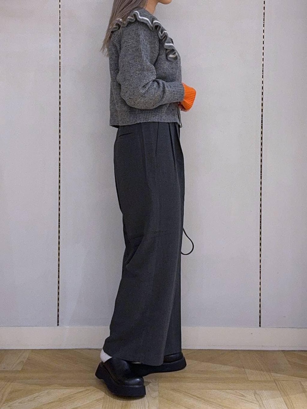 ホワイト系のニット/セーター、グレー系のその他パンツ、ブラック系のショルダーバッグを着用したレディースの冬コーディネートの2枚目の写真