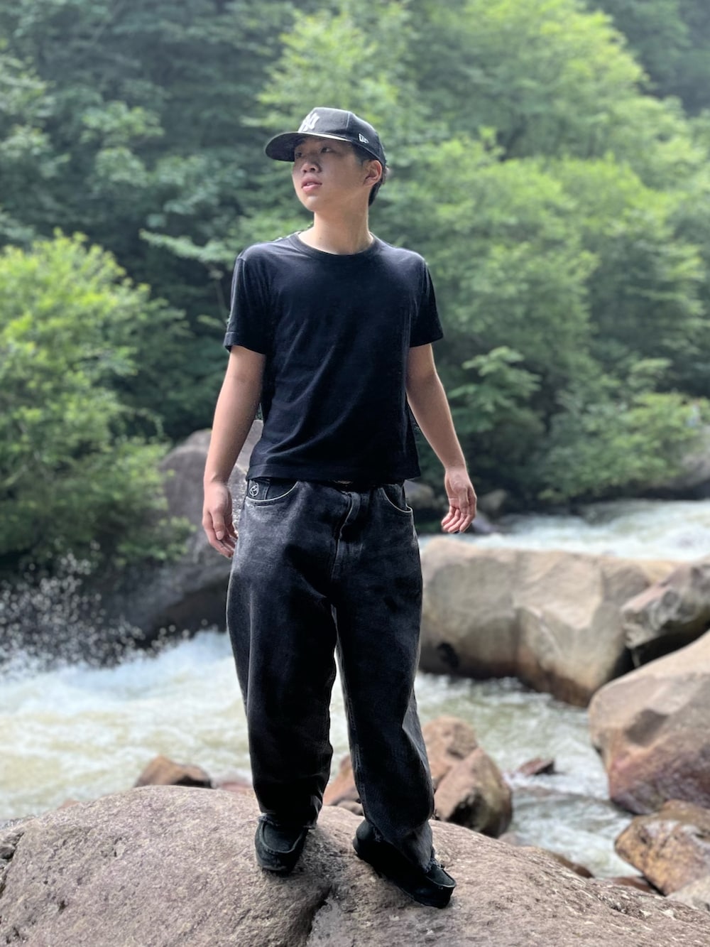 ブラック系のブーツ、ブラック系のデニムパンツ、ブルー系のキャップを着用したメンズの夏コーディネートの3枚目の写真