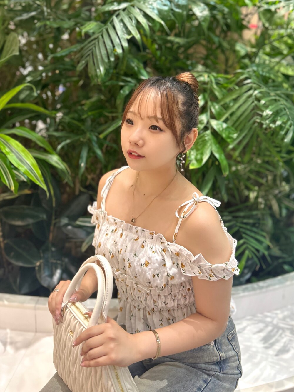 ホワイト系のシャツ/ブラウス、ホワイト系のスカート、ホワイト系のハンドバッグを着用したレディースの夏コーディネートの2枚目の写真