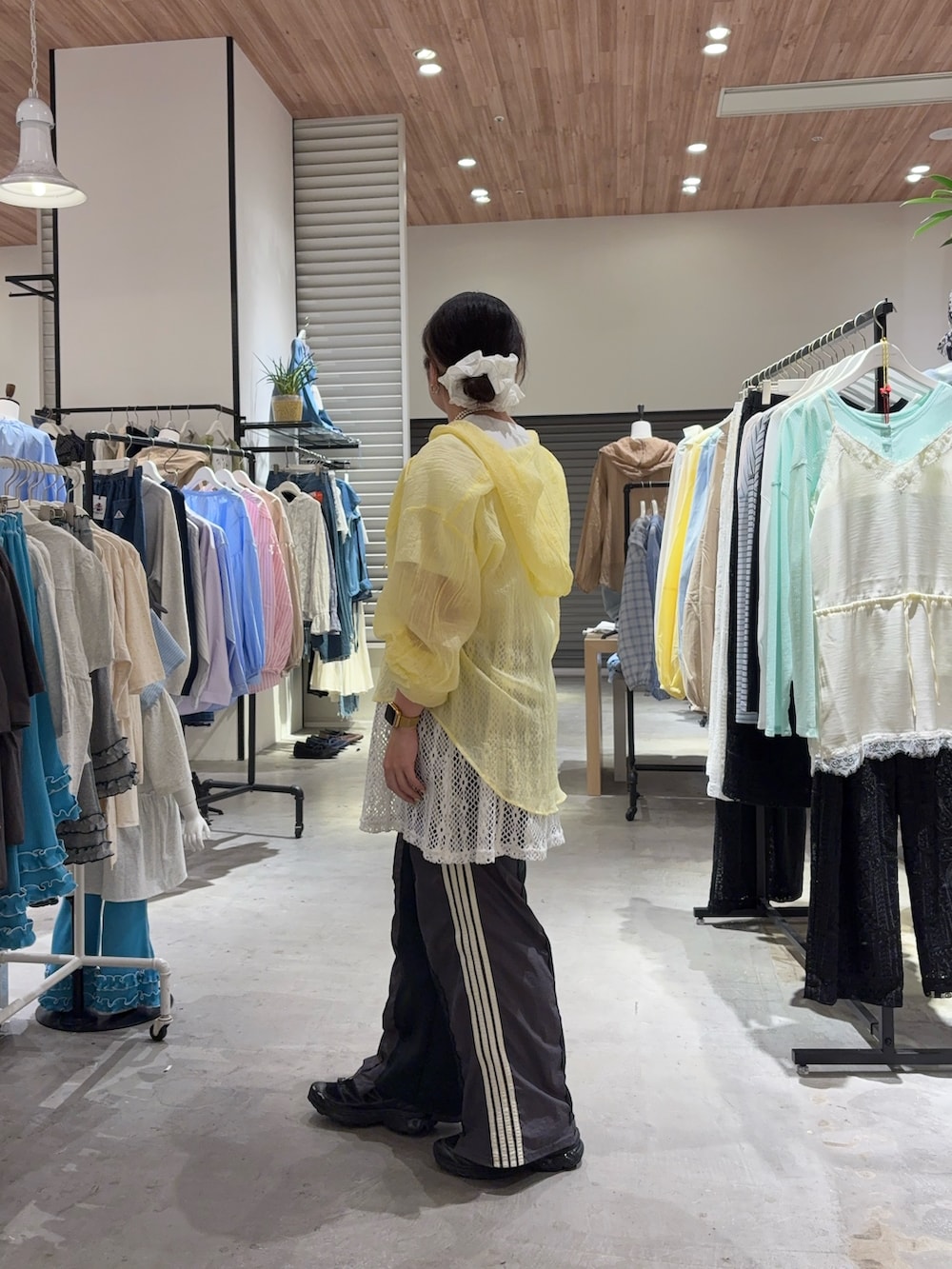 イエロー系のシャツ/ブラウス、ホワイト系のキャミソール、グレー系のスウェットパンツを着用したレディースの春コーディネートの2枚目の写真