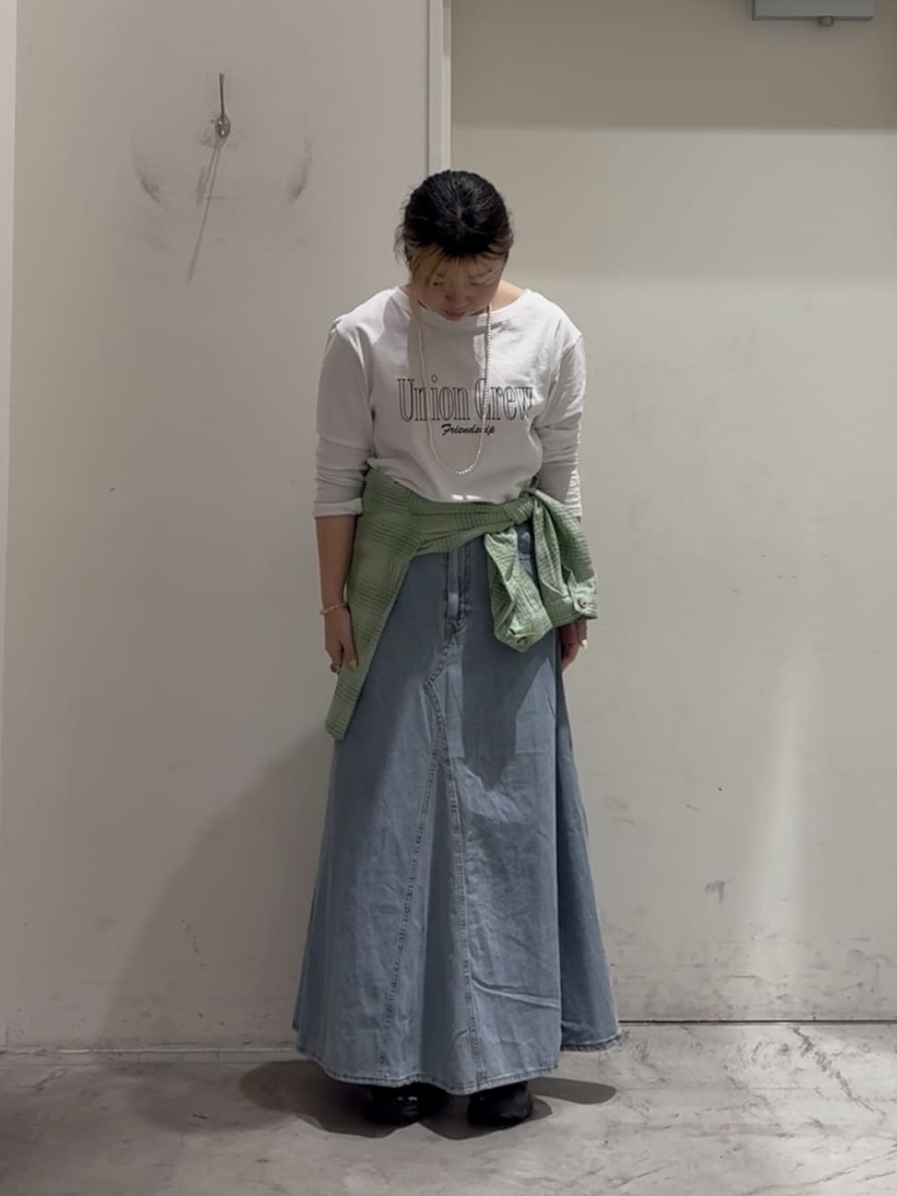 グリーン系のシャツ/ブラウス、ホワイト系のTシャツ/カットソー、ブルー系のスカートを着用したレディースの春コーディネートの3枚目の写真