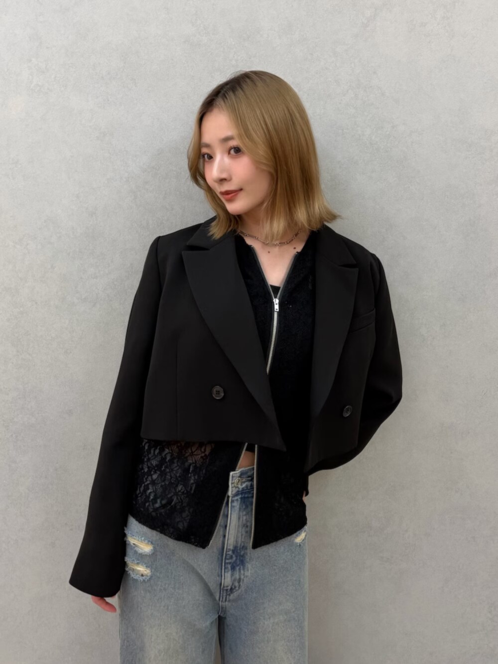 ブラック系のパンプス、ブルー系のデニムパンツ、ブラック系のテーラードジャケットを着用したレディースの春コーディネートの7枚目の写真