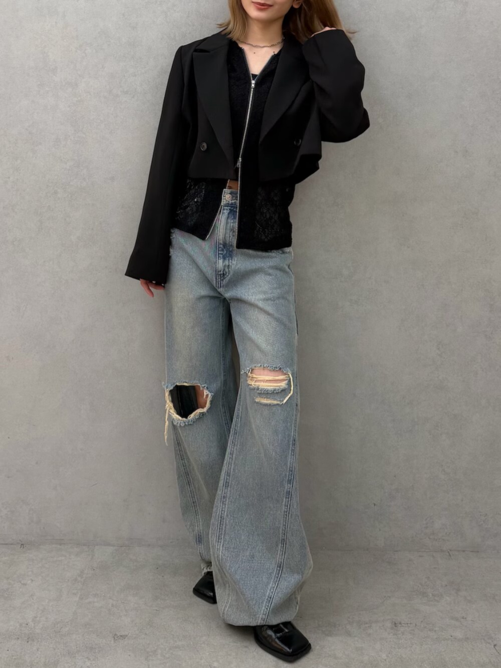 ブラック系のパンプス、ブルー系のデニムパンツ、ブラック系のテーラードジャケットを着用したレディースの春コーディネートの5枚目の写真