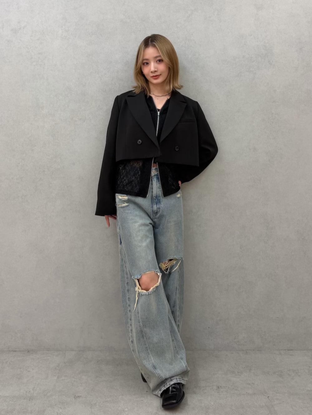 ブラック系のパンプス、ブルー系のデニムパンツ、ブラック系のテーラードジャケットを着用したレディースの春コーディネートの4枚目の写真