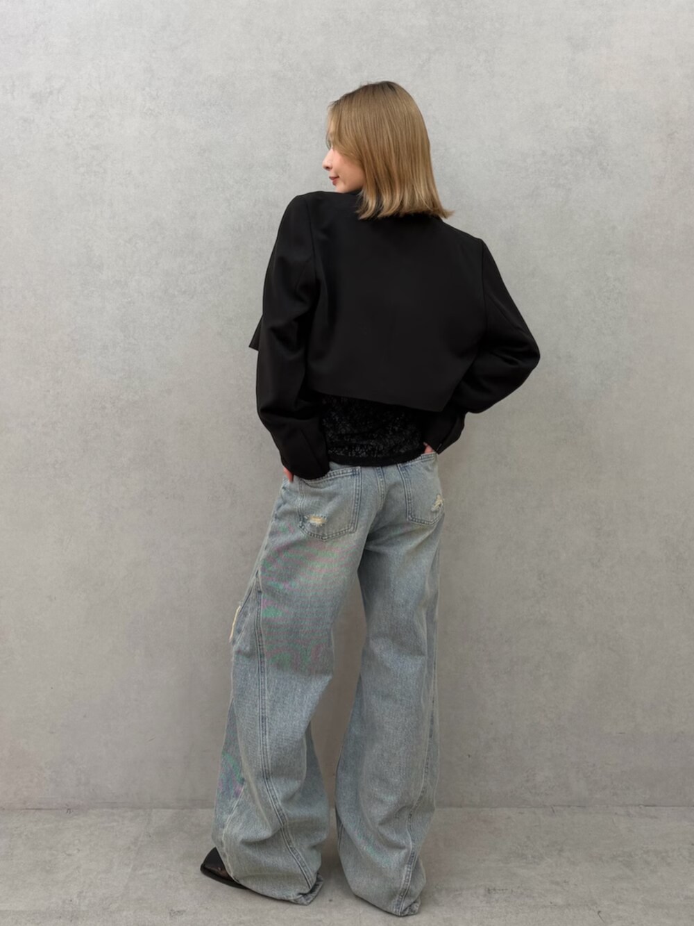 ブラック系のパンプス、ブルー系のデニムパンツ、ブラック系のテーラードジャケットを着用したレディースの春コーディネートの6枚目の写真