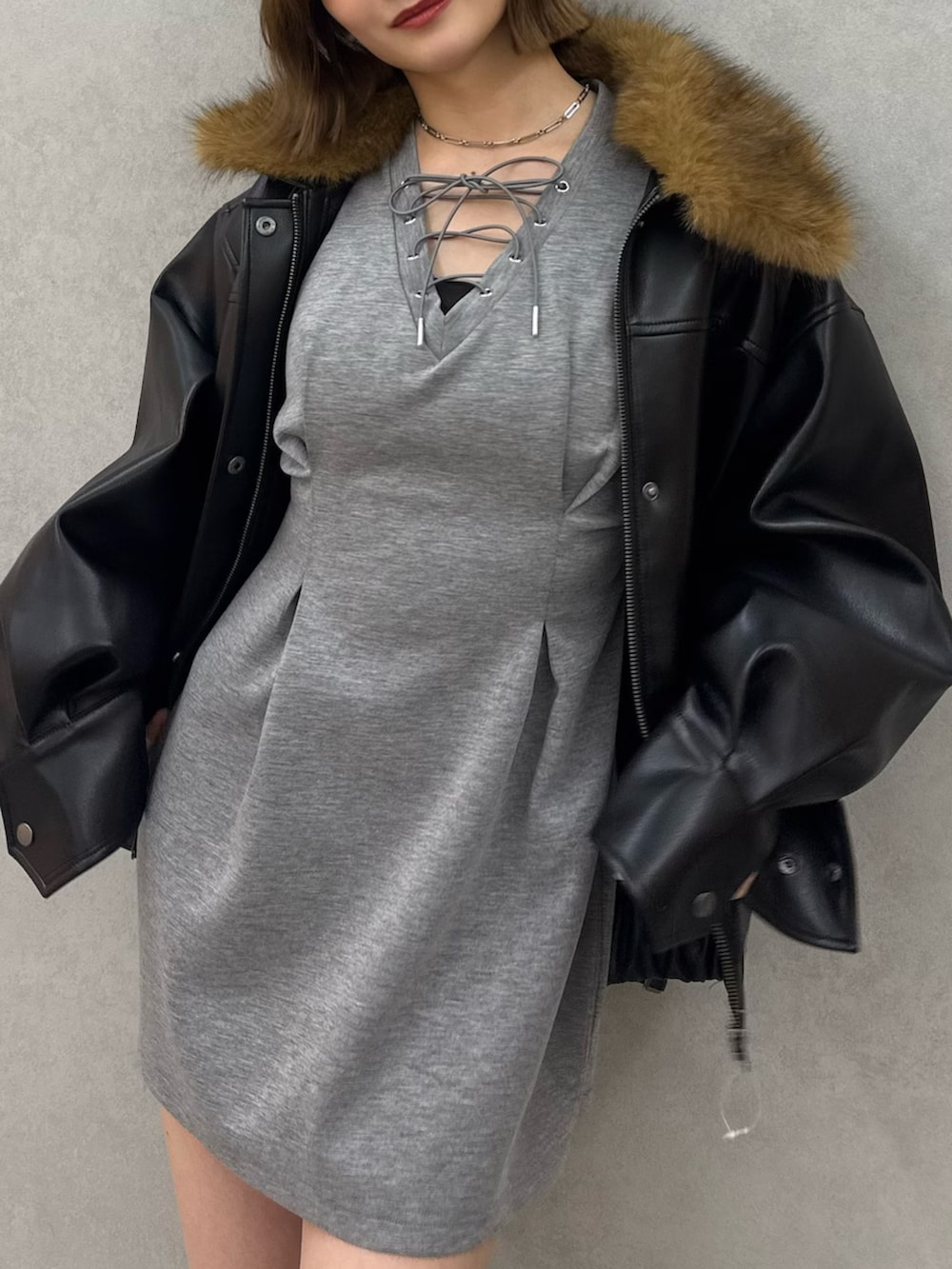 ブラック系のブルゾン、グレー系のワンピース、ブラック系のブーツを着用したレディースの冬コーディネートの6枚目の写真