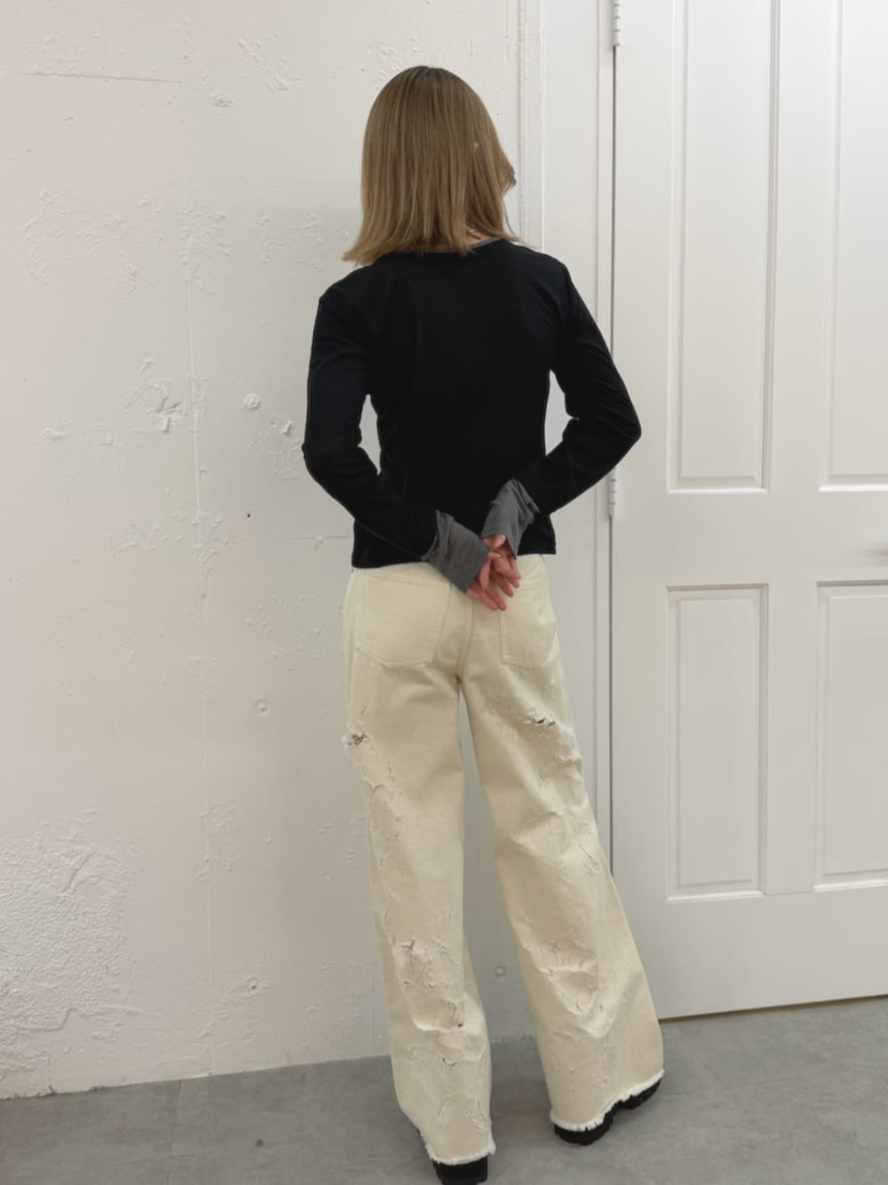 ホワイト系のデニムパンツ、ブラック系のカーディガン/ボレロ、ブラウン系のブーツを着用したレディースの春コーディネートの4枚目の写真