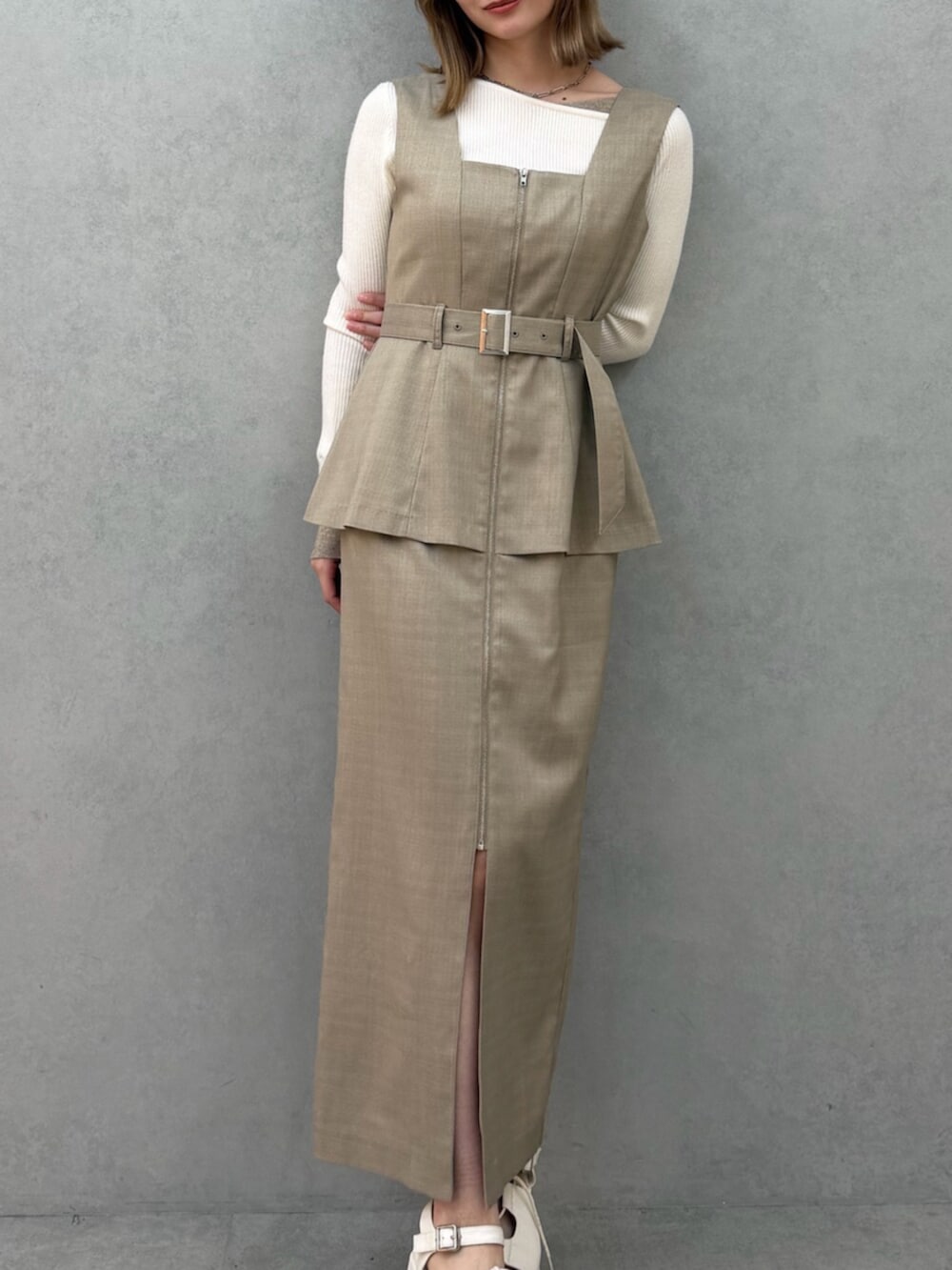 ベージュ系のジャンパースカート、ホワイト系のニット/セーター、ホワイト系のサンダルを着用したレディースの春コーディネートの6枚目の写真