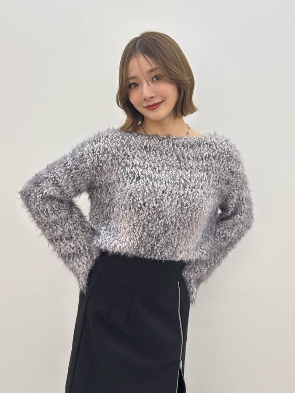 ブルー系のニット/セーター、ブラック系のブーツ、ブラック系のスカートを着用したレディースの冬コーディネートの3枚目の写真