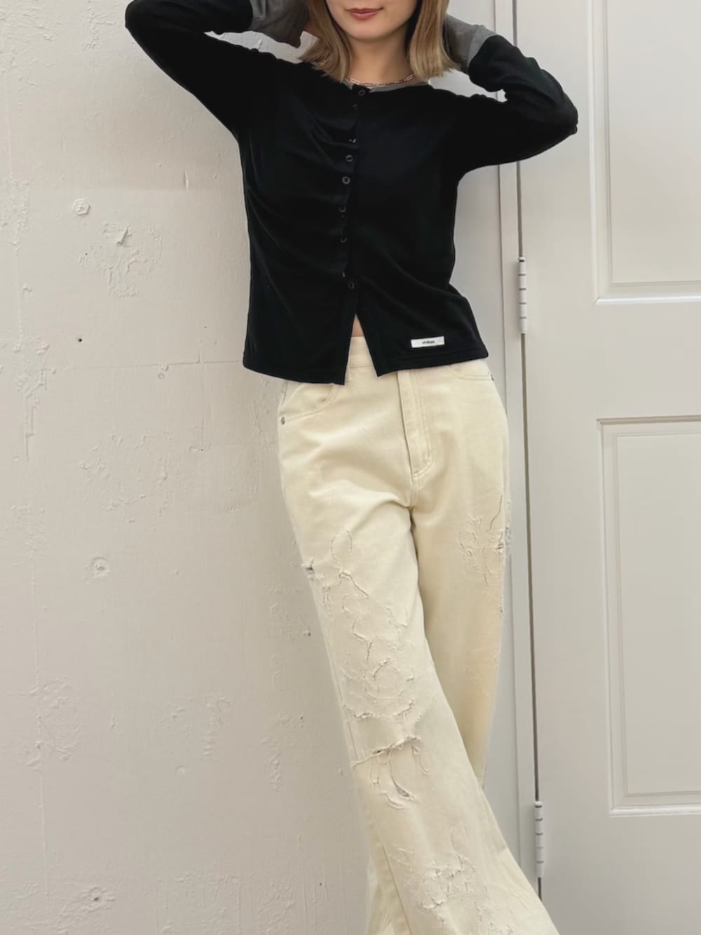 ホワイト系のデニムパンツ、ブラック系のカーディガン/ボレロ、ブラウン系のブーツを着用したレディースの春コーディネートの5枚目の写真