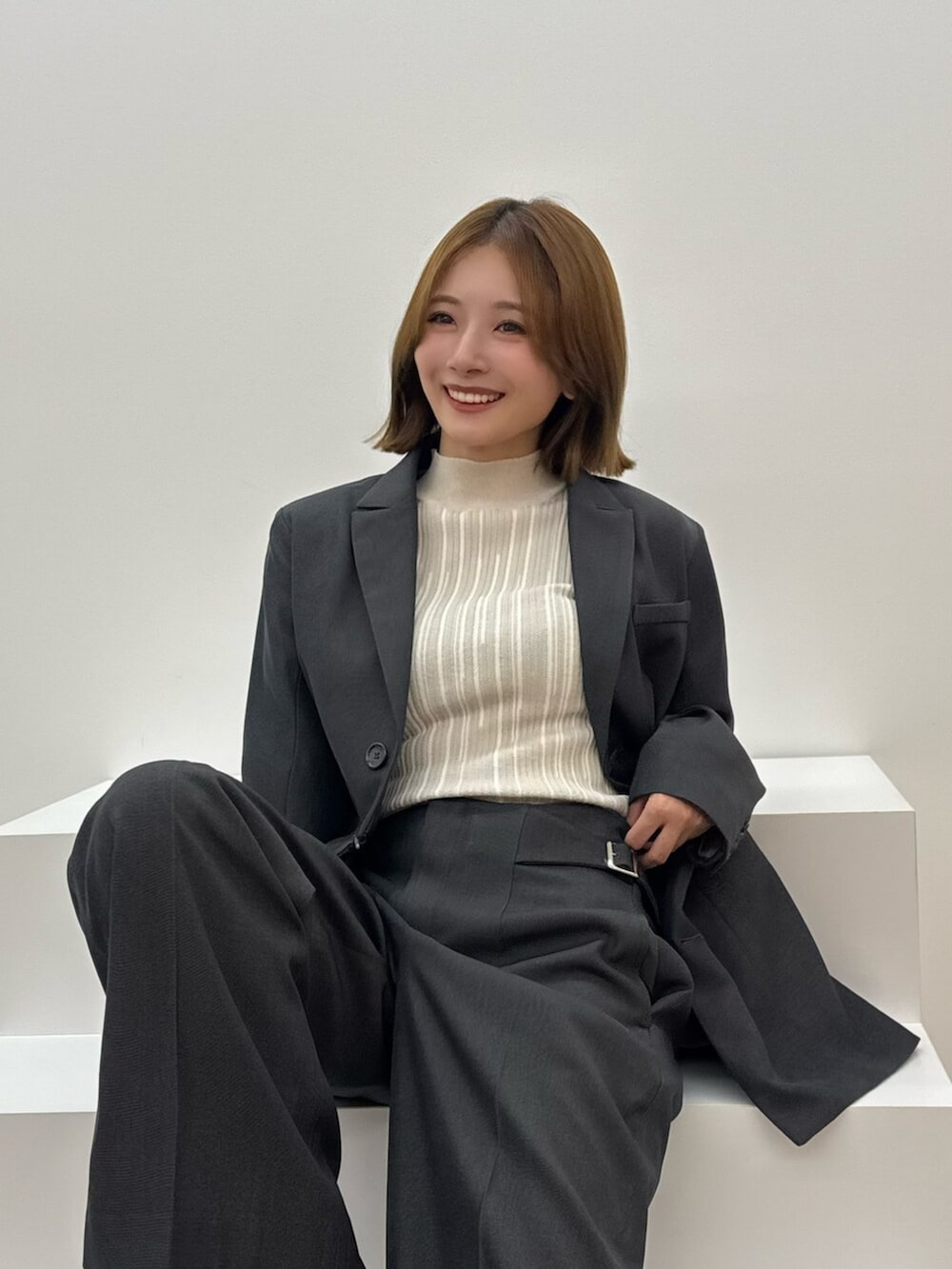 ブラウン系のサンダル、グレー系のテーラードジャケット、グレー系のスラックスを着用したレディースの夏コーディネートの5枚目の写真