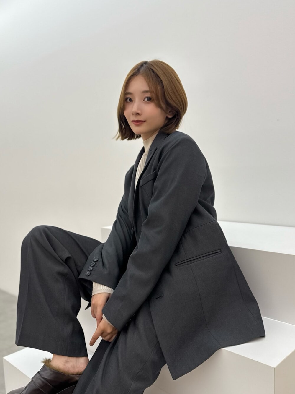 ブラウン系のサンダル、グレー系のテーラードジャケット、グレー系のスラックスを着用したレディースの夏コーディネートの2枚目の写真