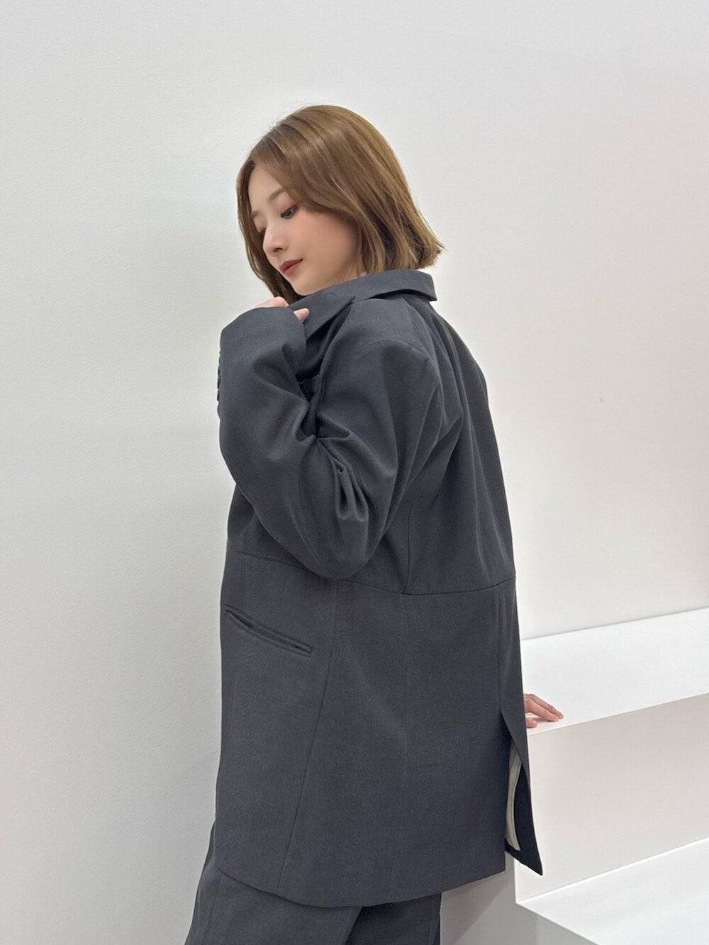 ブラウン系のサンダル、グレー系のテーラードジャケット、グレー系のスラックスを着用したレディースの夏コーディネートの3枚目の写真