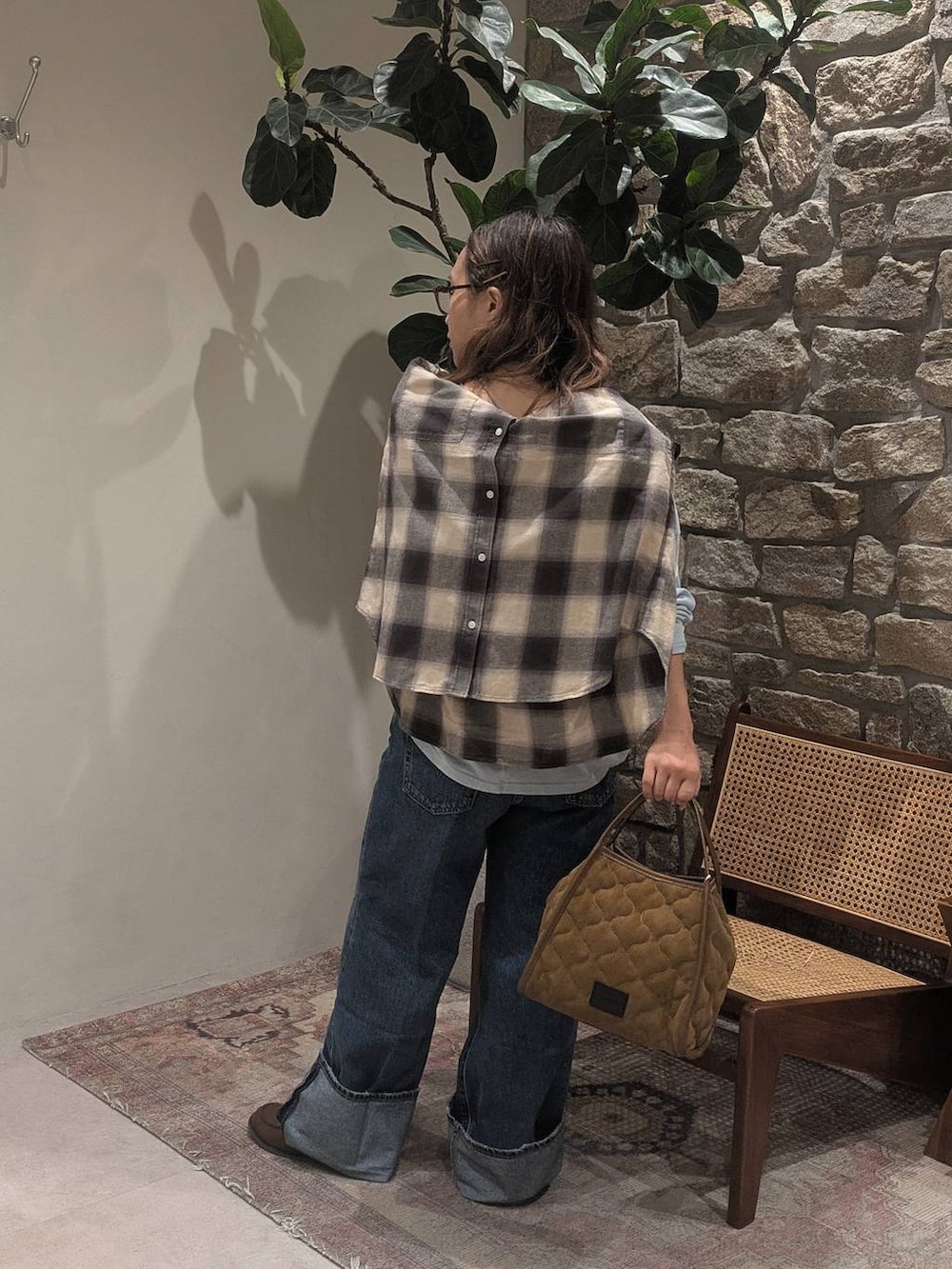 ブルー系のデニムパンツ、ベージュ系のシャツ/ブラウス、ブラウン系のモカシン/デッキシューズを着用したレディースの夏コーディネートの2枚目の写真