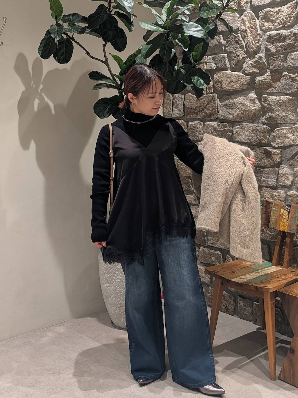 ブルー系のデニムパンツ、その他のブーツ、ブラック系のニット/セーターを着用したレディースの冬コーディネートの4枚目の写真