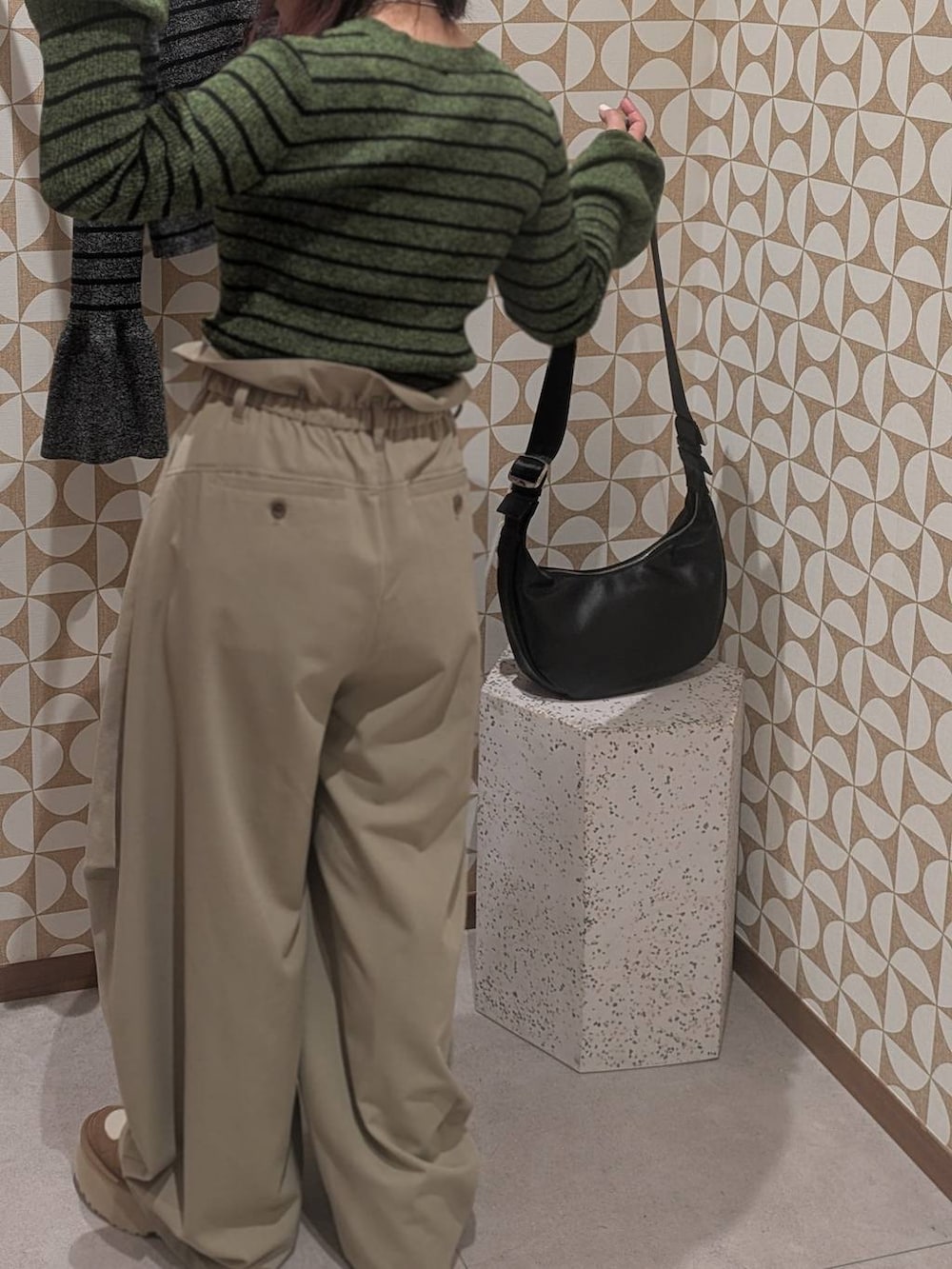 ブラック系のショルダーバッグ、ブラック系のニット/セーター、グリーン系のニット/セーターを着用したレディースの冬コーディネートの3枚目の写真