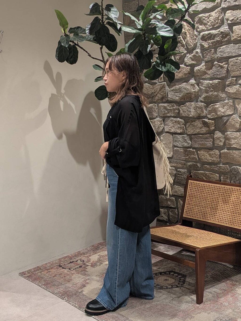 ブラック系のローファー、ベージュ系のショルダーバッグ、ブルー系のデニムパンツを着用したレディースの秋コーディネートの3枚目の写真