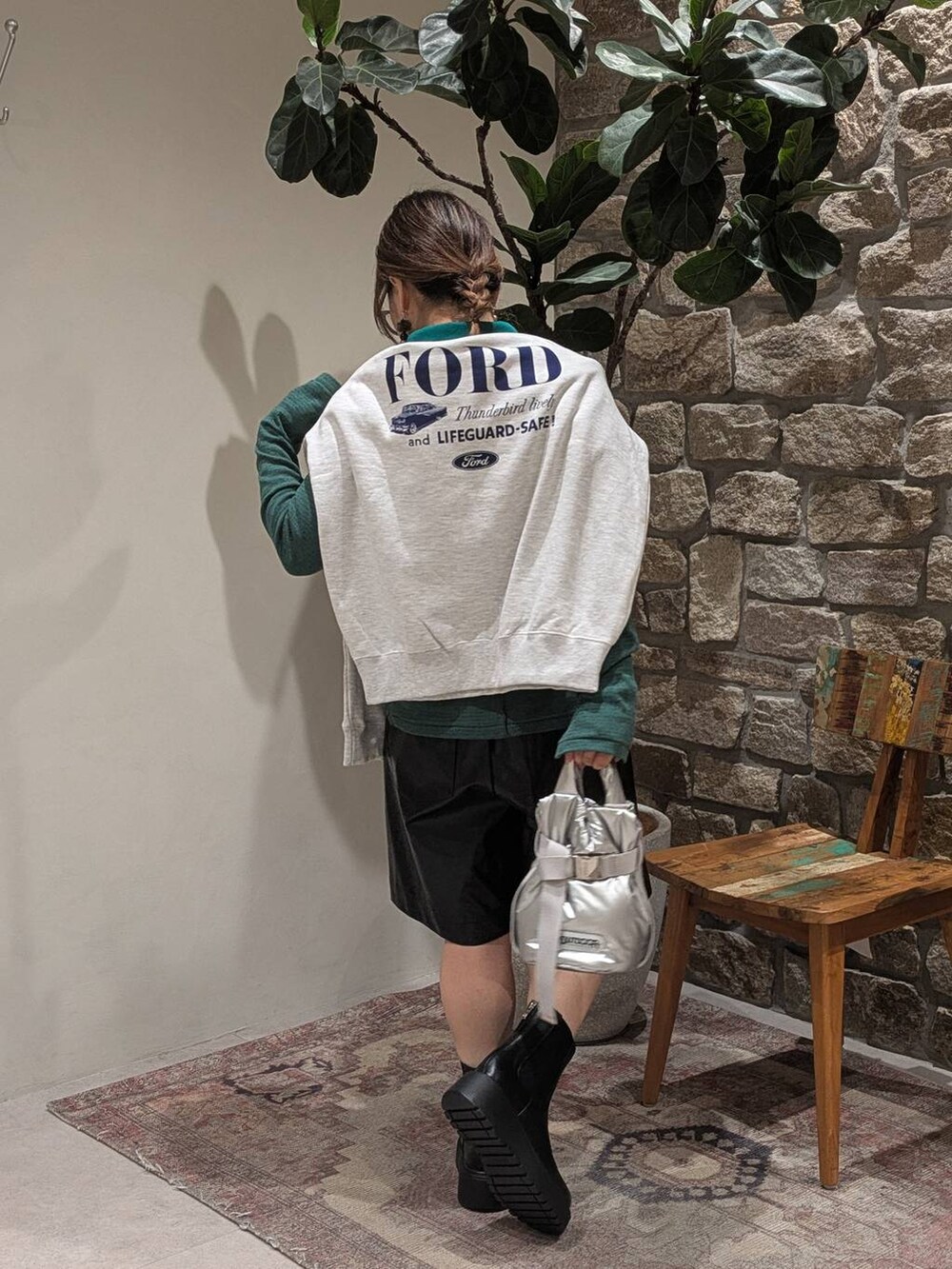 グリーン系のTシャツ/カットソー、ベージュ系のスウェット、ブラック系のブーツを着用したレディースの秋コーディネートの3枚目の写真