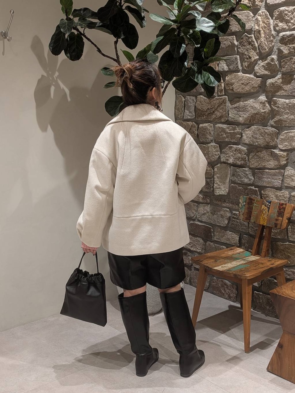 ブラック系のブーツ、ブラック系のハンドバッグを着用したレディースの秋コーディネートの5枚目の写真