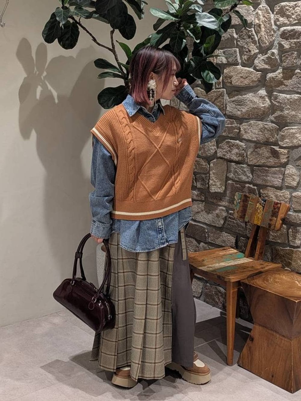 イエロー系のベスト、ブルー系のシャツ/ブラウス、ベージュ系のスカートを着用したレディースの冬コーディネートの2枚目の写真