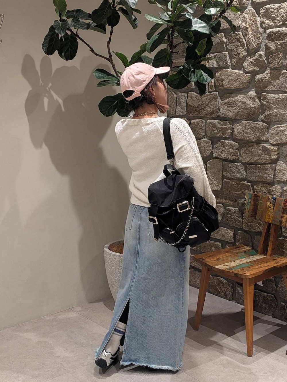 グレー系のスニーカー、ブルー系のデニムスカート、ブラック系のバックパック/リュックを着用したレディースの冬コーディネートの4枚目の写真