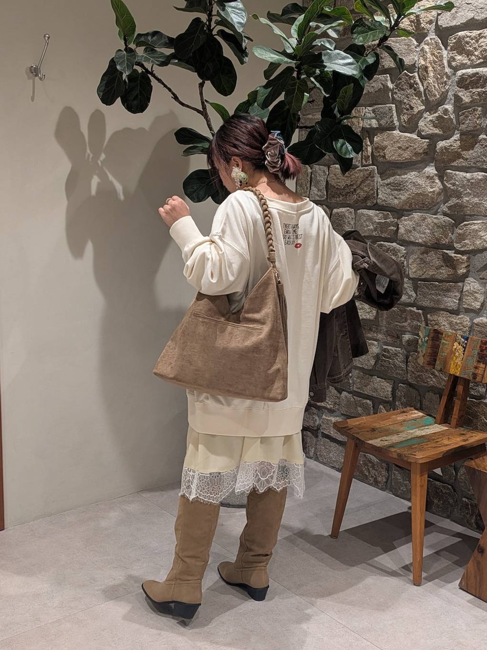 ベージュ系のトートバッグ、ベージュ系のブーツ、ベージュ系のスウェットを着用したレディースの冬コーディネートの4枚目の写真