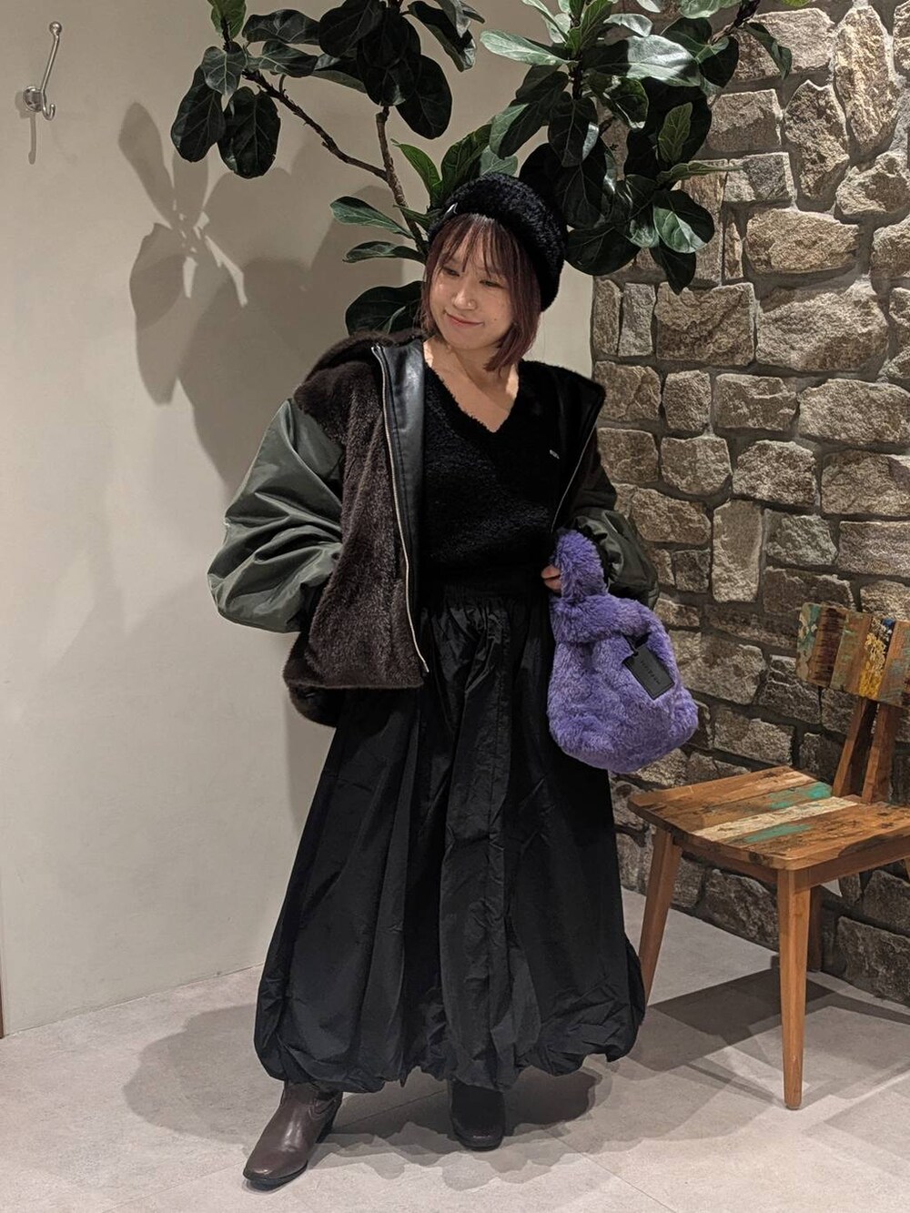 ブラウン系のブーツ、ブラウン系のブルゾン、パープル系のハンドバッグを着用したレディースの秋コーディネートの2枚目の写真