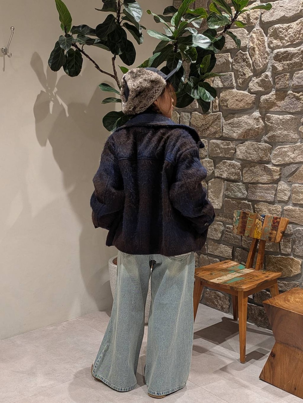 ブラウン系のショルダーバッグ、レッド系のニット/セーター、ブルー系のデニムパンツを着用したレディースの秋コーディネートの2枚目の写真