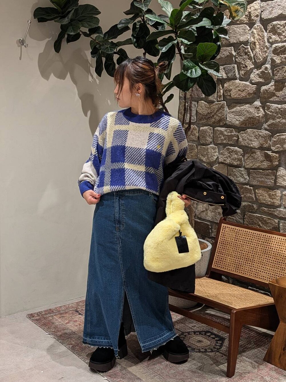 ブルー系のデニムスカート、イエロー系のハンドバッグ、ブルー系のニット/セーターを着用したレディースの冬コーディネートの3枚目の写真