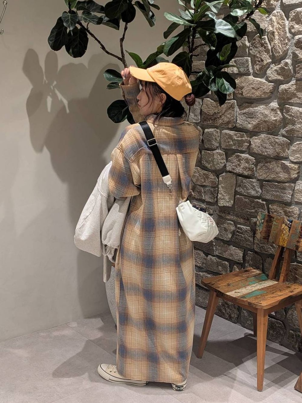 ホワイト系のスニーカー、イエロー系のシャツワンピース、ホワイト系のショルダーバッグを着用したレディースの冬コーディネートの5枚目の写真