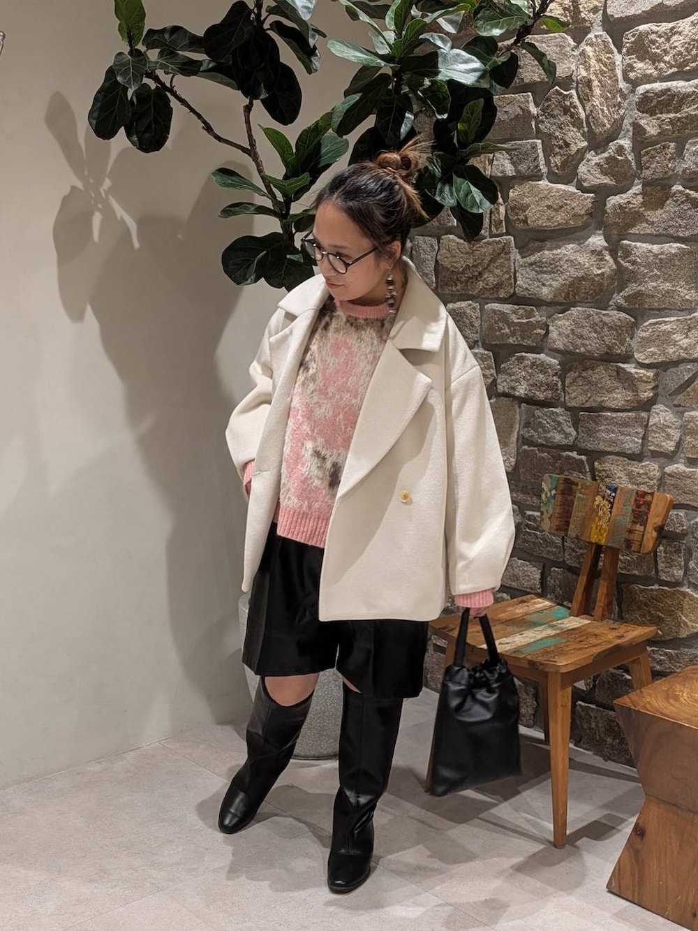 ブラック系のブーツ、ブラック系のハンドバッグを着用したレディースの秋コーディネートの3枚目の写真