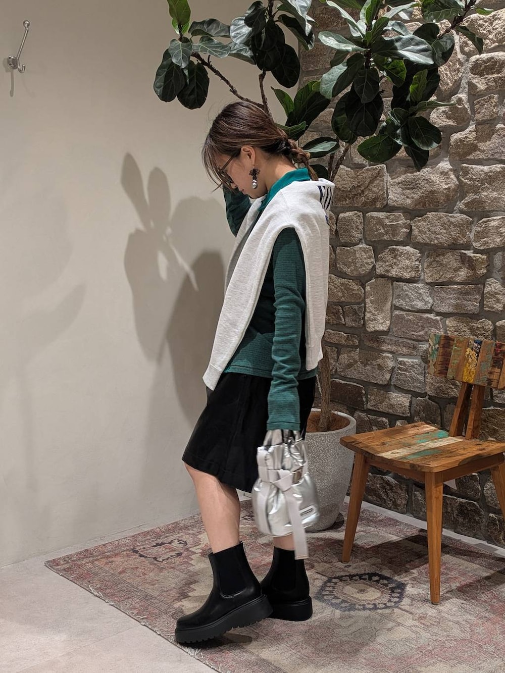 グリーン系のTシャツ/カットソー、ベージュ系のスウェット、ブラック系のブーツを着用したレディースの秋コーディネートの2枚目の写真