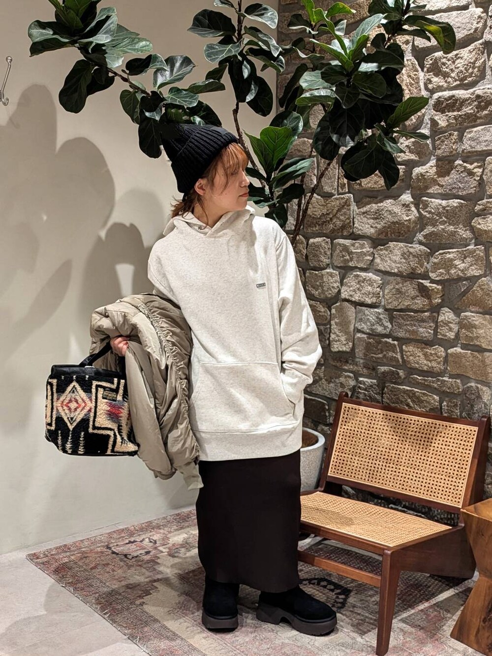 ブラウン系のスカート、グリーン系のブルゾン、グレー系のパーカーを着用したレディースの秋コーディネートの3枚目の写真